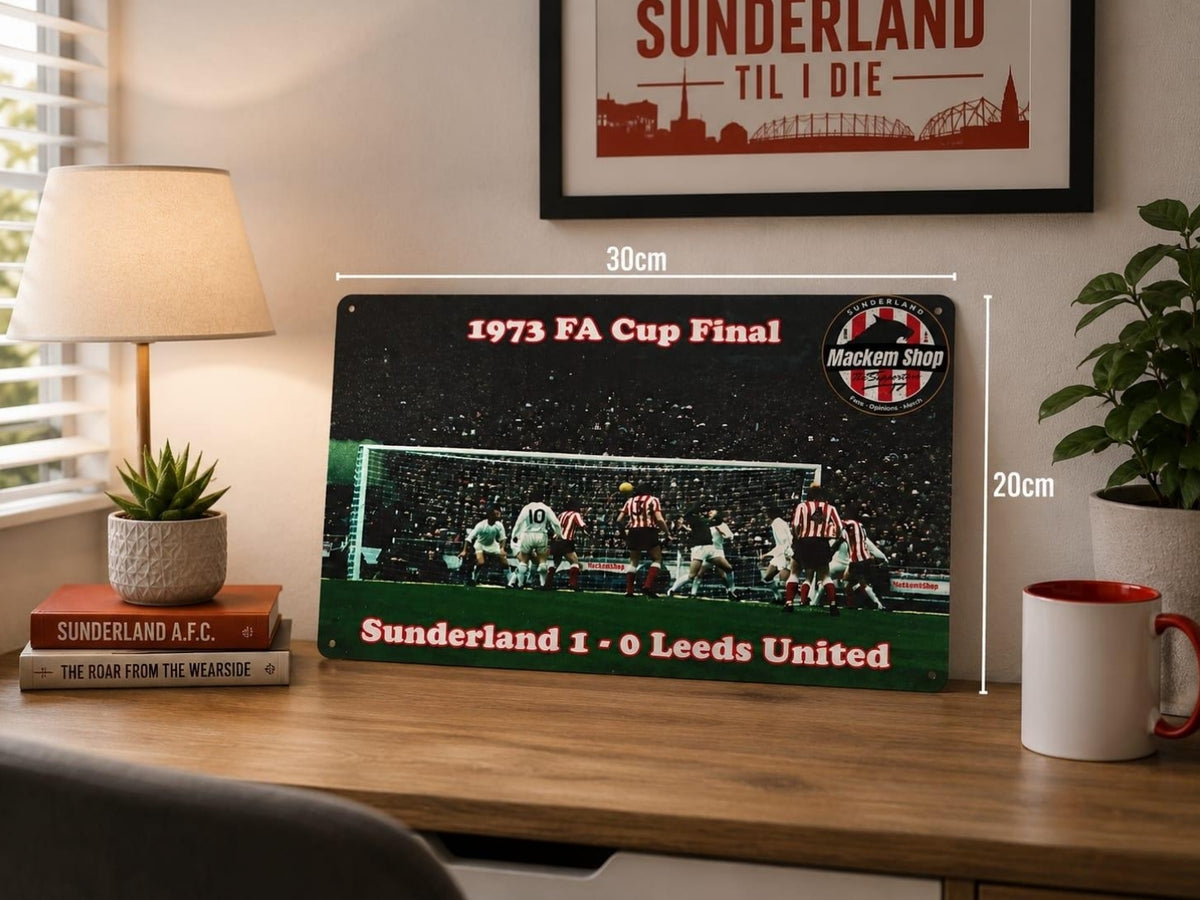A Sunderland football Metal Sign displayed on a wooden desk in a styled room setting, with dimension labels showing 30cm by 20cm. The Metal Sign features the 1973 FA Cup Final match graphic with Sunderland and Leeds United text.