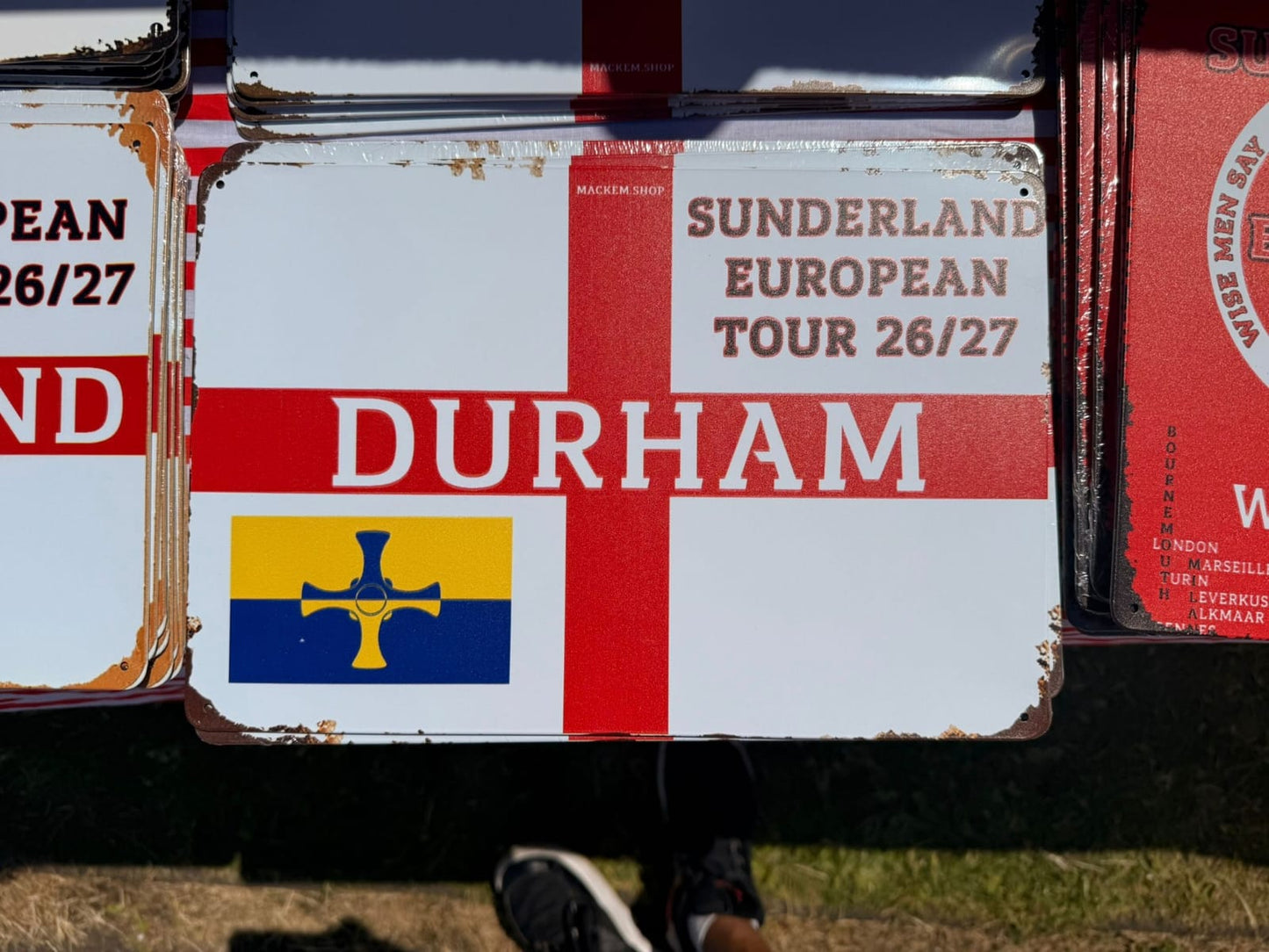 Vintage sign with 'Sunderland European Tour 26/27 Durham' text and a flag design.