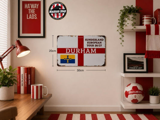 A Sunderland AFC Durham football-themed wall sign displayed in a styled room setting. The rectangular metal sign features the red and white Sunderland flag with 'DURHAM' in red text, alongside the Sunderland European Tour 26/27 text.