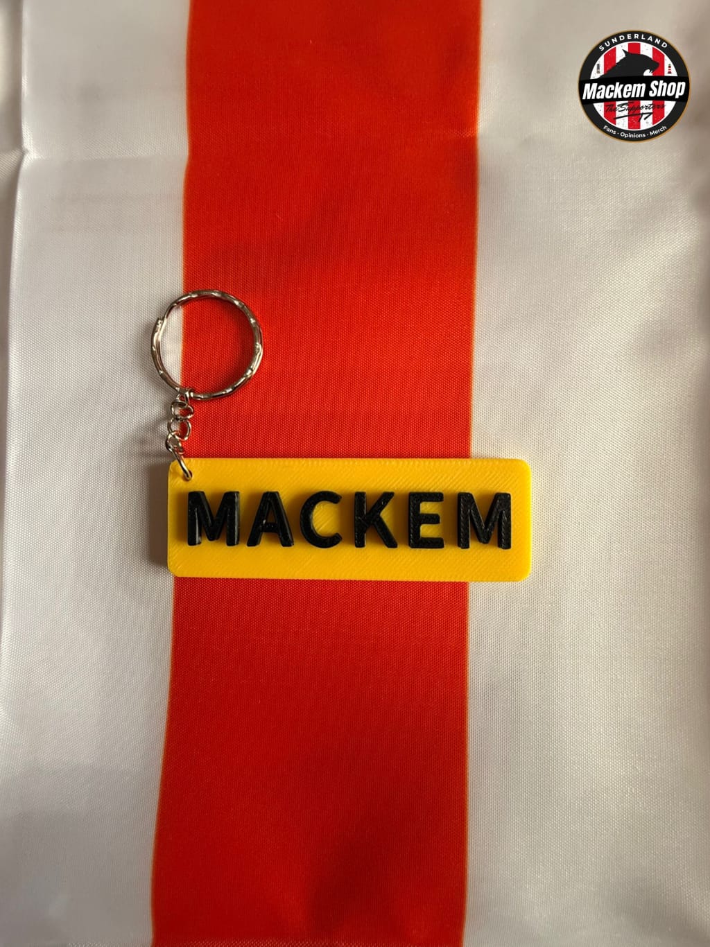 Yellow keychain with 'MACKEM' text on a red and white striped background
