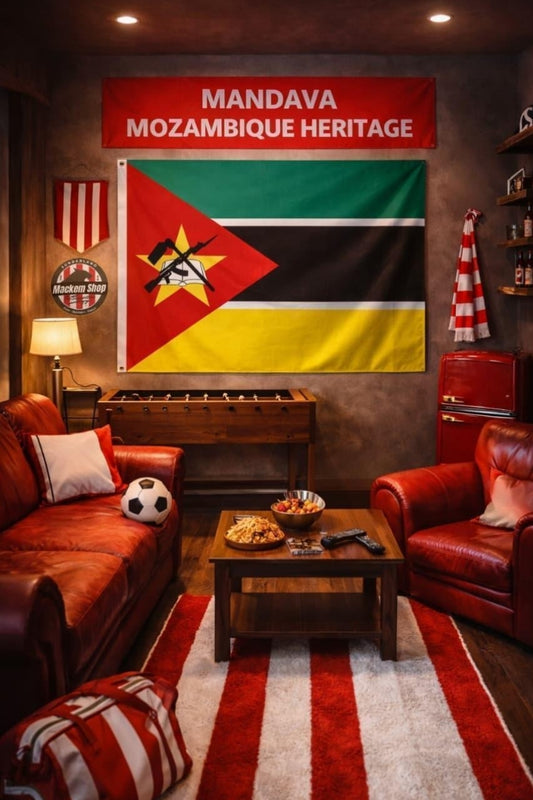 A styled home theater or lounge room featuring a large wall banner and flag of Mozambique ('Mandava Mozambique Heritage') above a foosball table. The room is furnished with red leather armchairs, a striped red and white rug, and a wooden coffee table.