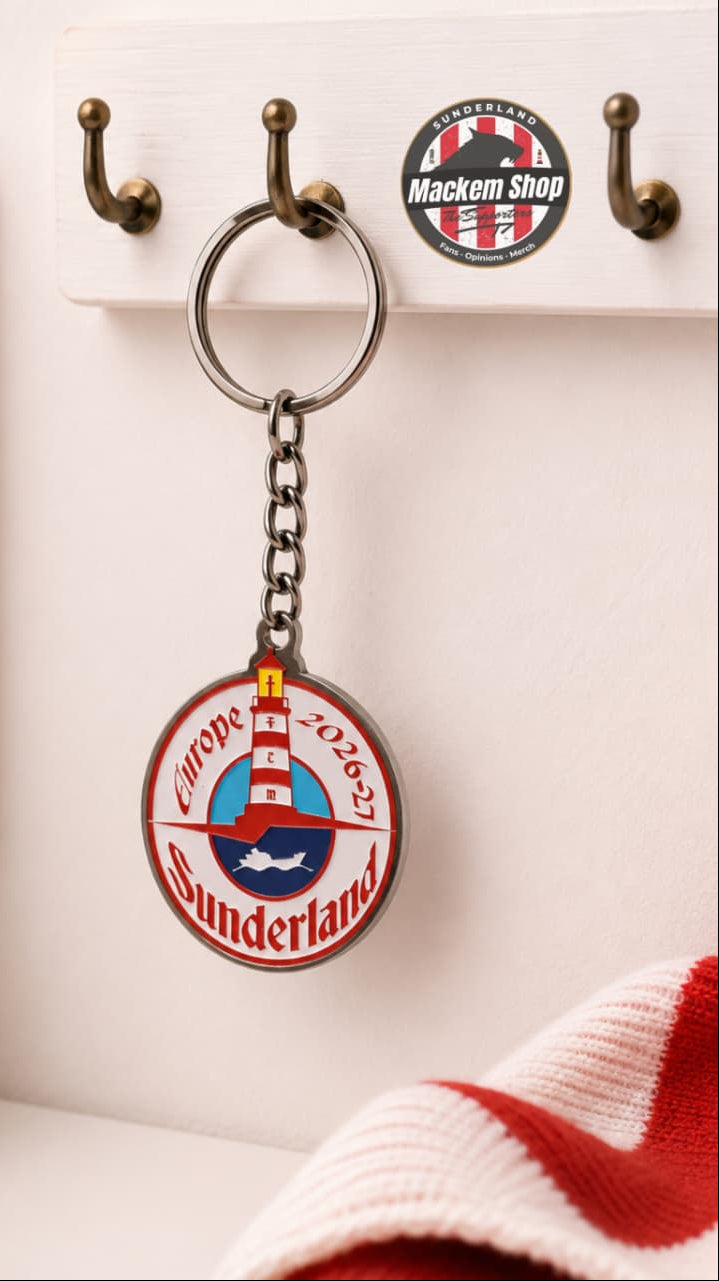 Keychain with Sunderland Europe 26/27 tour on a hook with a plant and red and white item in the background