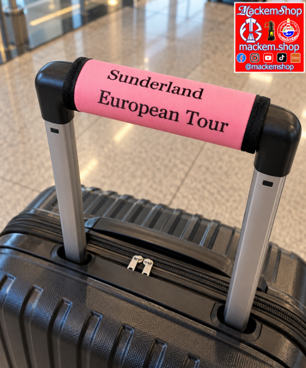 A black hard-shell suitcase with an extended telescoping handle, featuring a bright pink handle wrap printed with 'Sunderland European Tour' in black text. The suitcase is photographed on a polished tiled floor in an airport or train station setting. A MackemShop Logo is visible on top right corner.