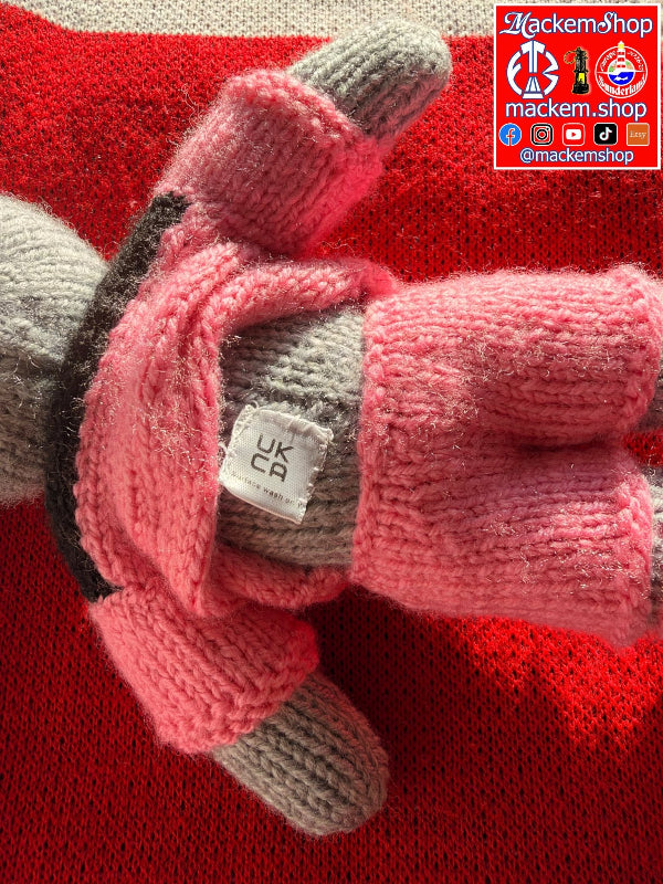 A close-up of a Rabbit on a sofa shown against a red knit background. A small white tag reads 'UK CA surface wash only'. A MackemShop Logo is visible on top right corner.