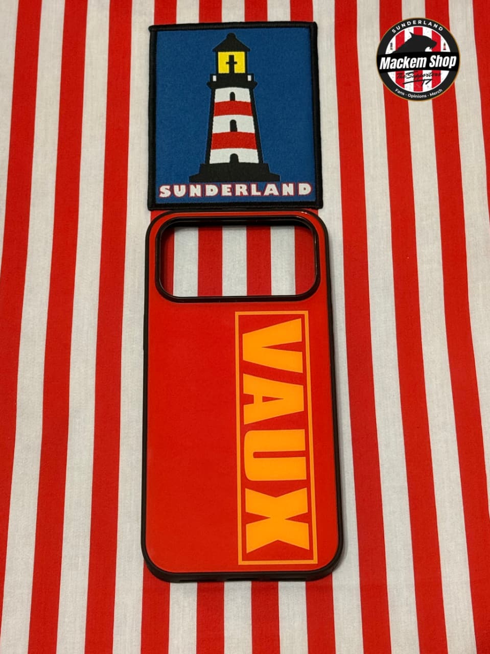 Phone case with Sunderland lighthouse design and Vaux branding on a red and white striped background.
