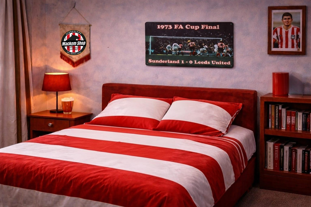 A bed dressed in red and white striped bedding, placed in a styled bedroom with a red wooden headboard, bedside tables, lamps, books, and wall decor a 1973 FA Cup Final Sunderland 1-0 Leeds United sign.