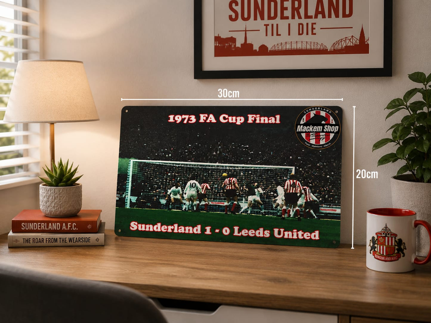 Metal sign commemorating the 1973 FA Cup Final between Sunderland and Leeds United on a desk with a lamp and mug.