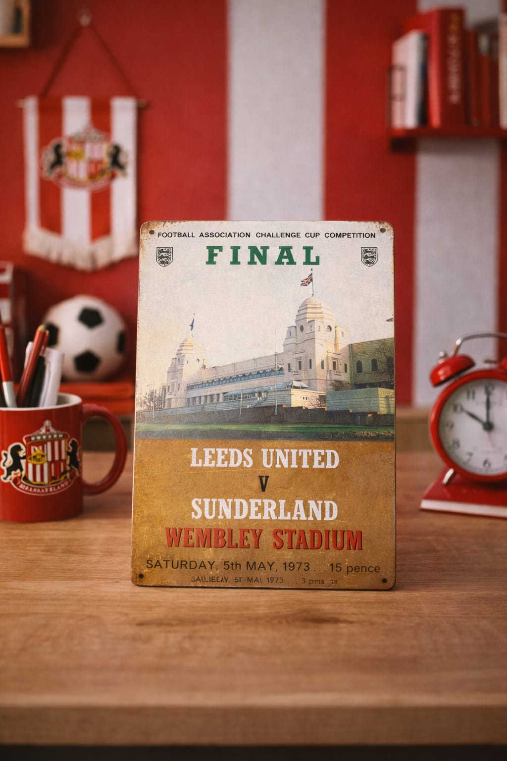 Vintage-style sign for Leeds United vs Sunderland match at Wembley Stadium on a wooden surface.