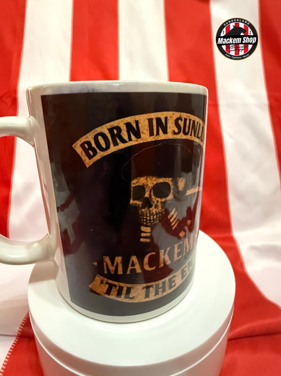 Mug with skull design and text on a red and white striped background