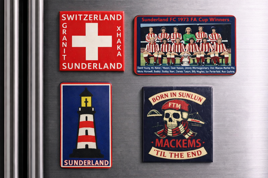 Four magnets on a refrigerator with different designs and text.