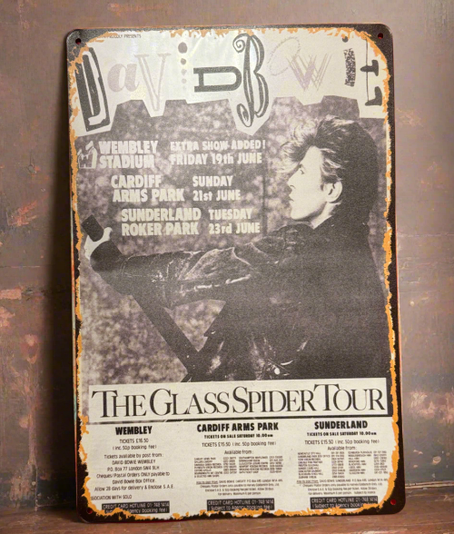 Mackem shop Metal sign with black and white image of a person and concert tour details on a textured surface.
