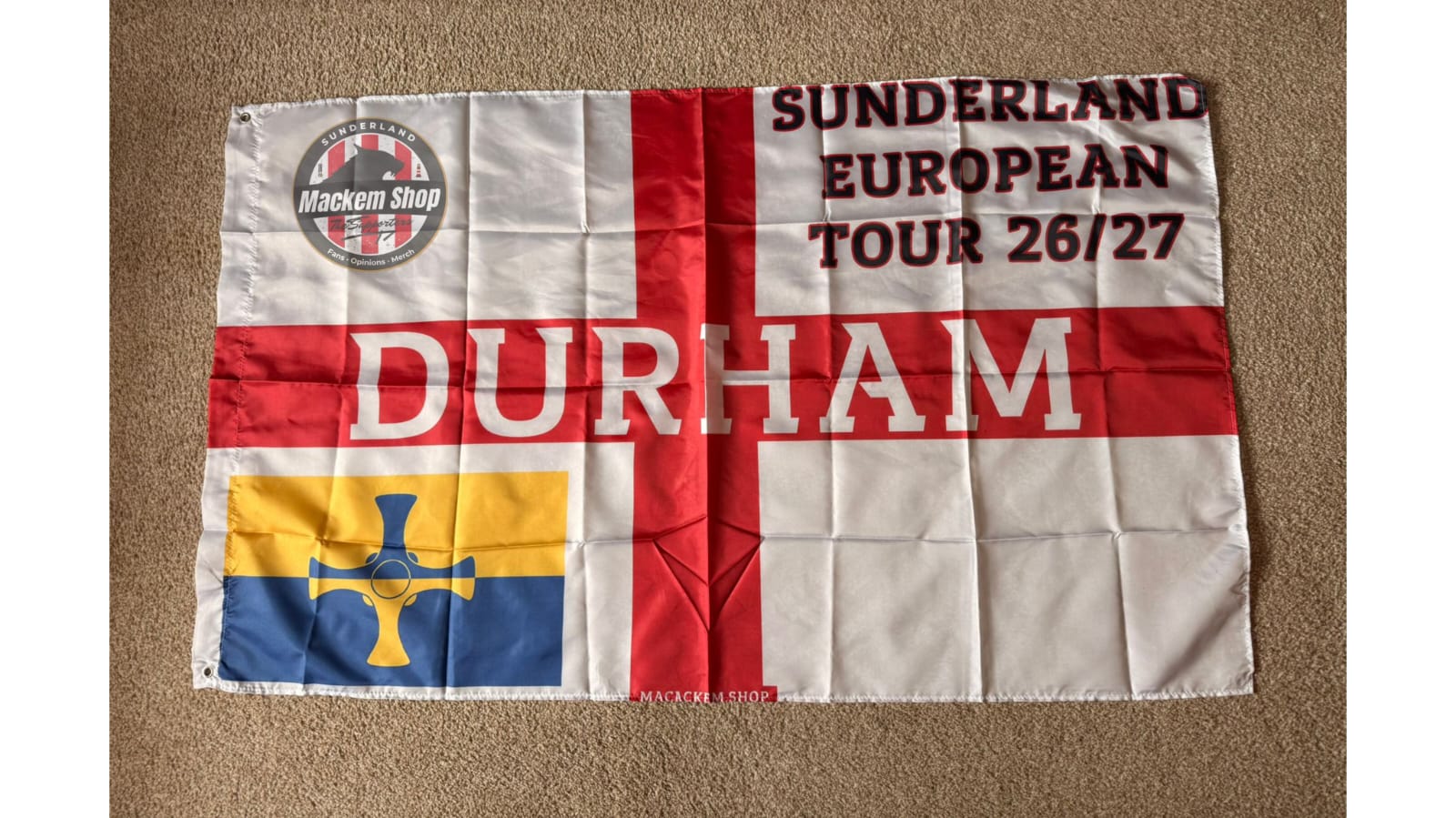 Flag with text and logos on a beige carpet