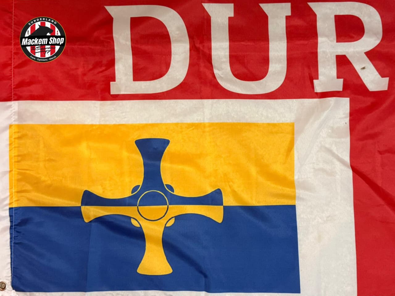 Flag with 'DUR' text and a cross design on a red, yellow, and blue background.