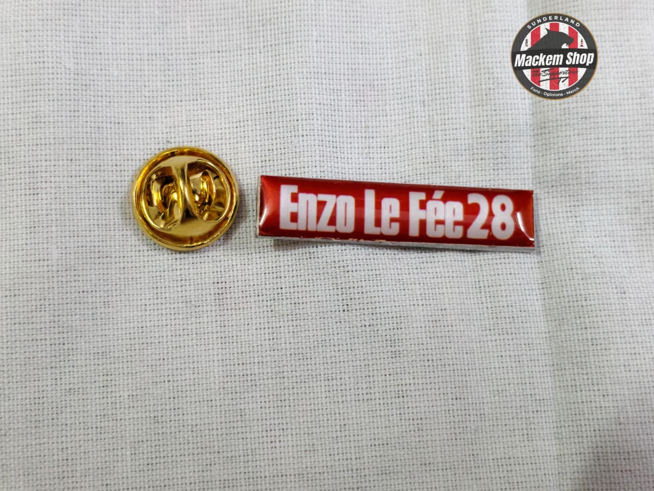 Red and white badge with 'Enzo Le Fée 28' text on a gray background
