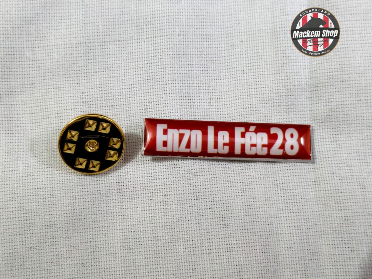 Two pins on a textured gray background with 'Mackem Shop' logo.