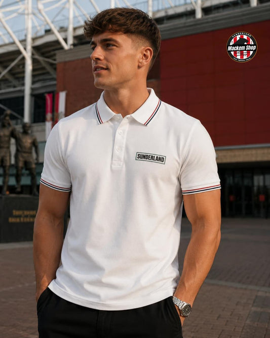 Man wearing a white polo shirt with 'Sunderland' logo outdoors.