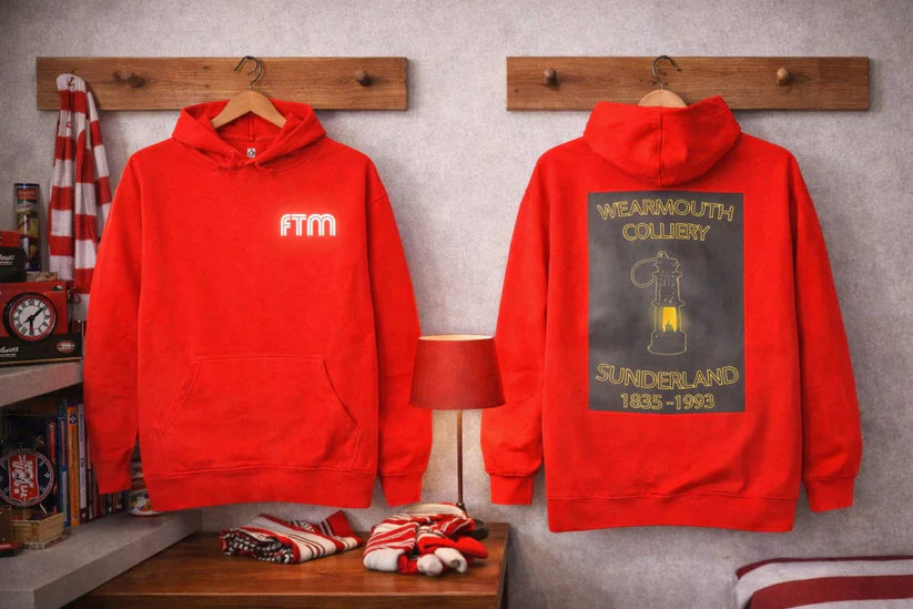Red hoodie with 'FTM' on the front and 'Wearmouth Colliery Sunderland 1825-1965' on the back, displayed on hangers against a gray wall.