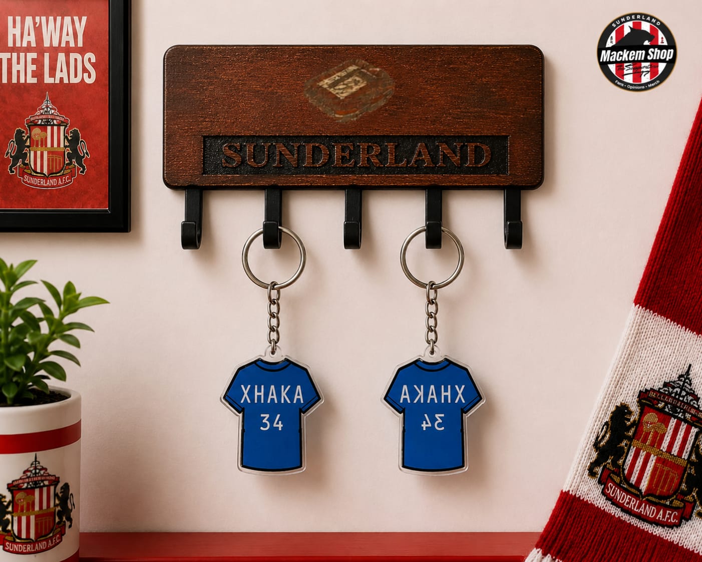 A wooden Sunderland football club key holder mounted on a wall, featuring two blue jersey-shaped keychains with player names and numbers. A Sunderland scarf, framed poster, and potted plant are visible in the styled setting.