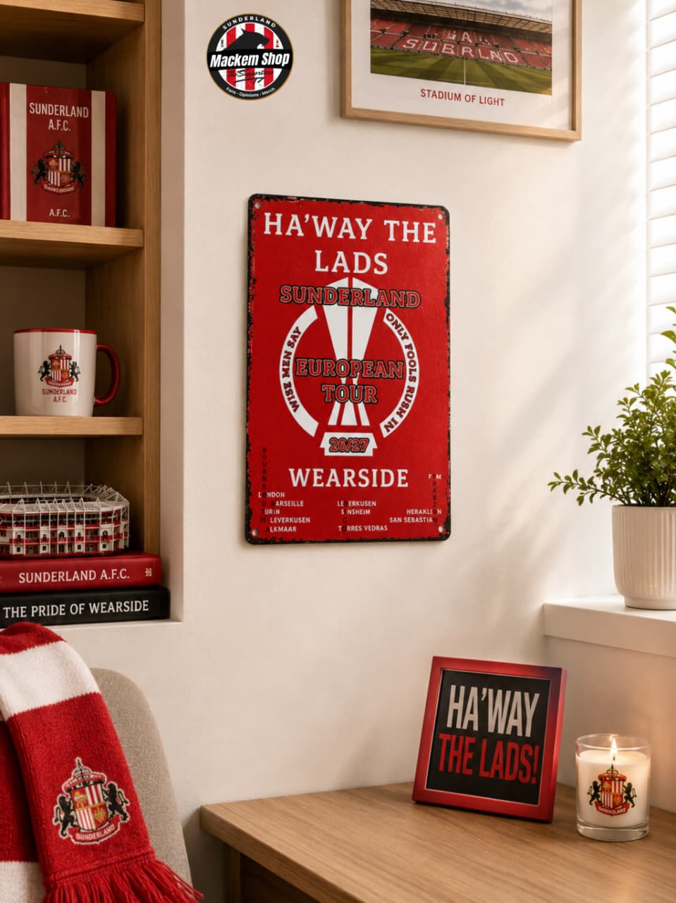 Red metal sign with 'Ha'way the Lads' text in a room setting with decor items.