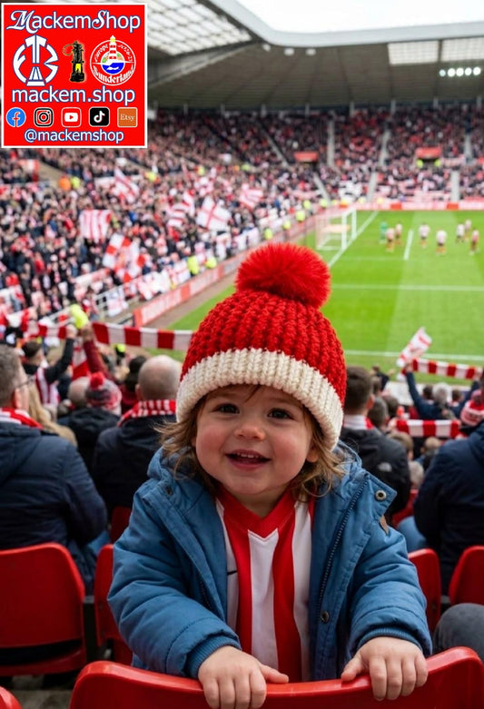 Handmade knitted Sunderland Baby red hat worn by a cute little girl in a stadium packed with fans with a Mackemshop logo in the top right corner.