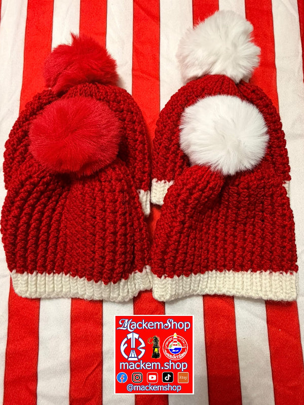 Two red knit Santa hats with white pom-poms and white ribbed trim, displayed side by side on a red and white striped fabric background. A 'MackemShop' logo sticker is placed at the bottom.