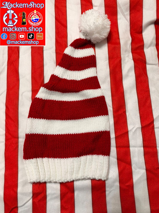 A red and white striped knit hat with a white pom-pom, laid flat on a red and white striped fabric background. A red and white MackemShop logo overlay is visible in the top-left corner.