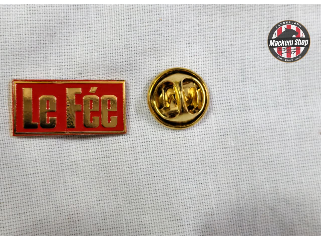 Yellow and red 'Le Fée' badge on a textured gray background with a Mackem Shop logo.