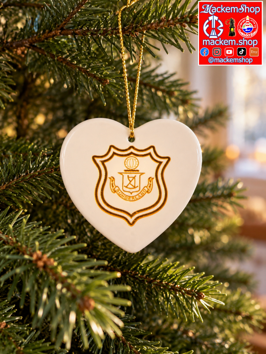 A white heart-shaped ceramic Christmas ornament hanging from a green pine tree branch. The ornament features a gold printed crest with the text 'SUNDERLAND' and a gold hanging string.