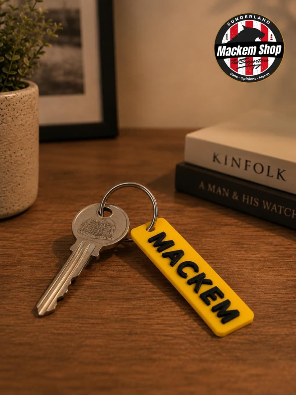 Keychain with 'MACKEM' on a wooden surface, featuring the MackemShop logo.
