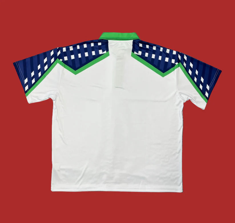 White polo shirt with blue and green accents on a red background