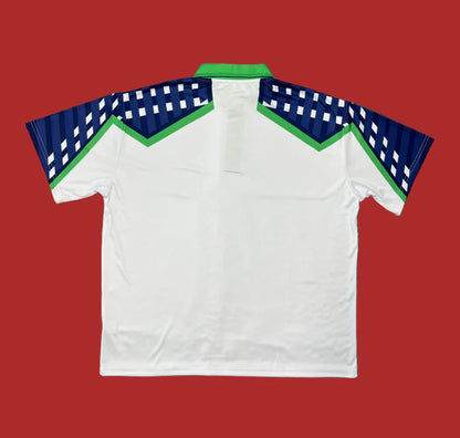 White polo shirt with blue and green accents on a red background
