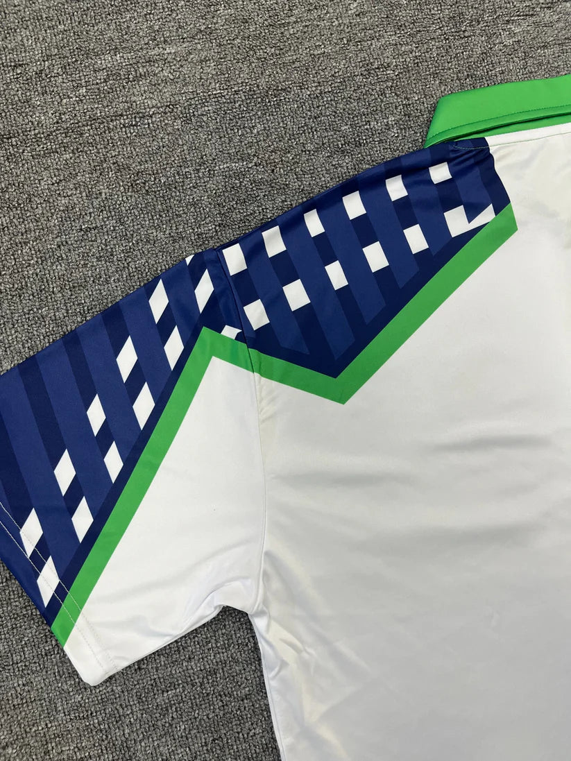 Close-up of a sports jersey with blue and green accents on a gray surface