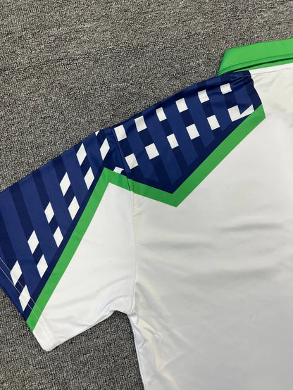 Close-up of a sports jersey with blue and green accents on a gray surface