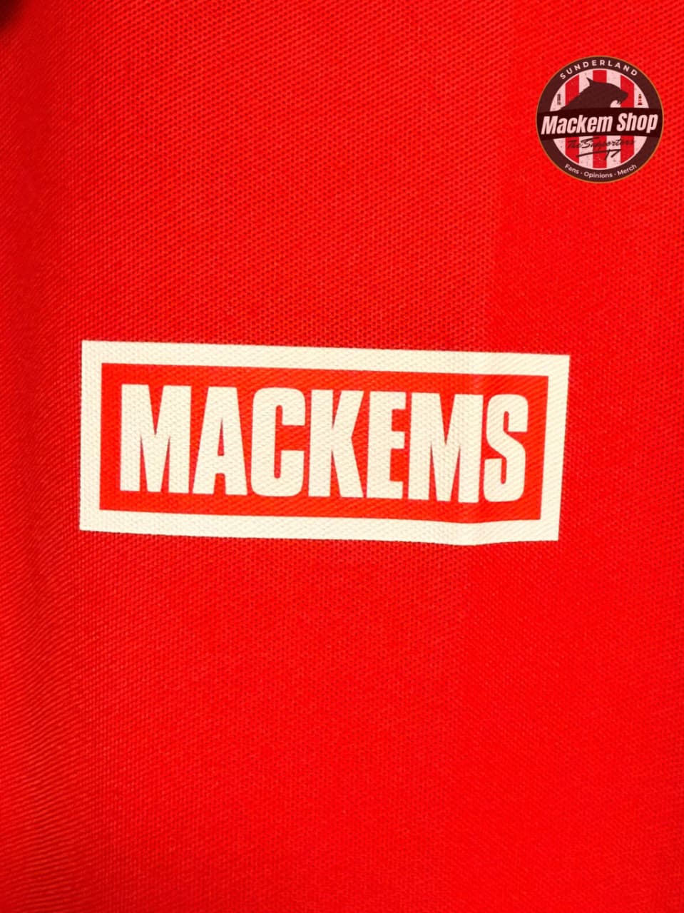 Red shirt with 'Mackems' logo and Mackem Shop badge on a red background