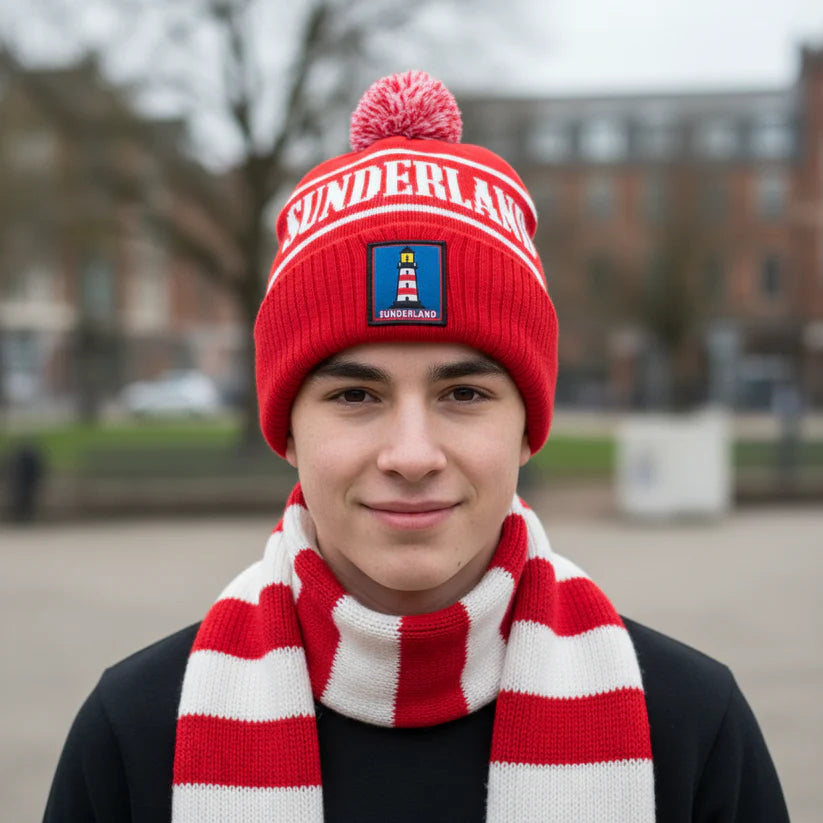 Person wearing a red 'Sunderland' beanie with Sunderland Lighthouse logo and scarf outdoors