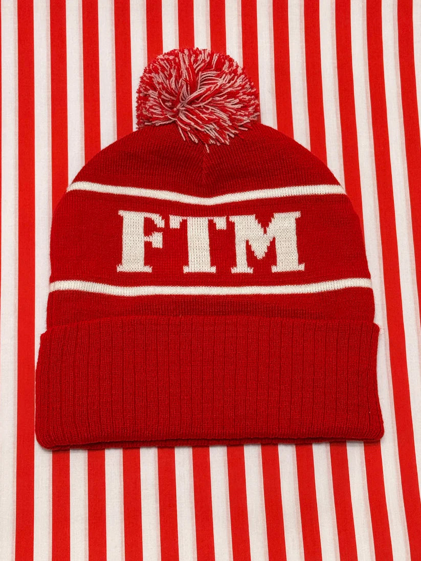 Red beanie with white 'FTM' text on a red and white striped background