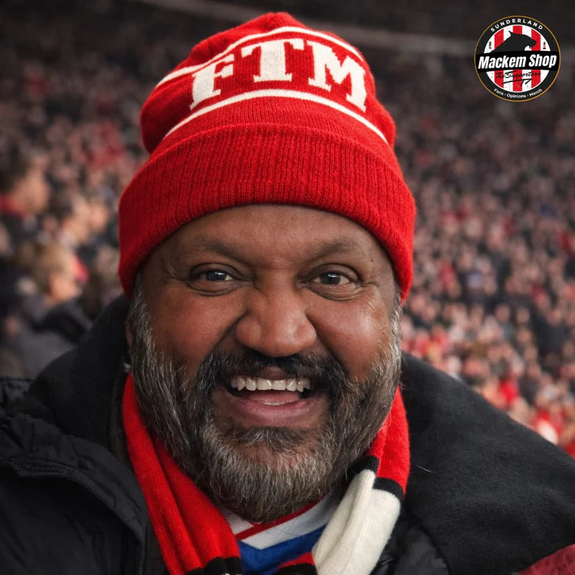 Man wearing a red 'FTM' beanie with a blurred crowd in the background