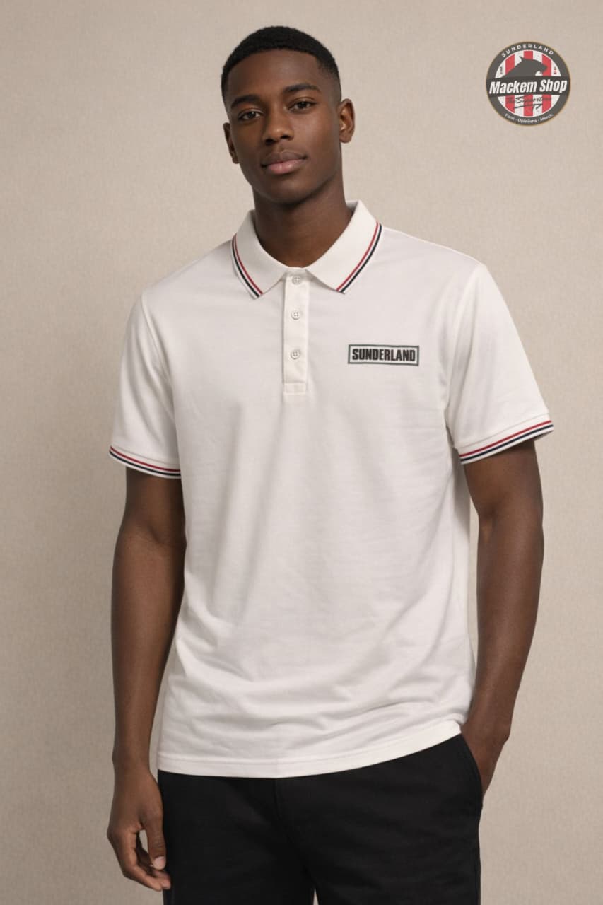 Man wearing a white polo Sunderland shirt with a logo on a beige background.