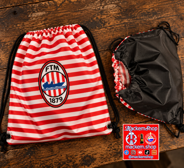 Two drawstring bags laid flat on a rustic wooden table. The left bag is red and white horizontally striped with a circular FTM 1879 crest printed on the front.