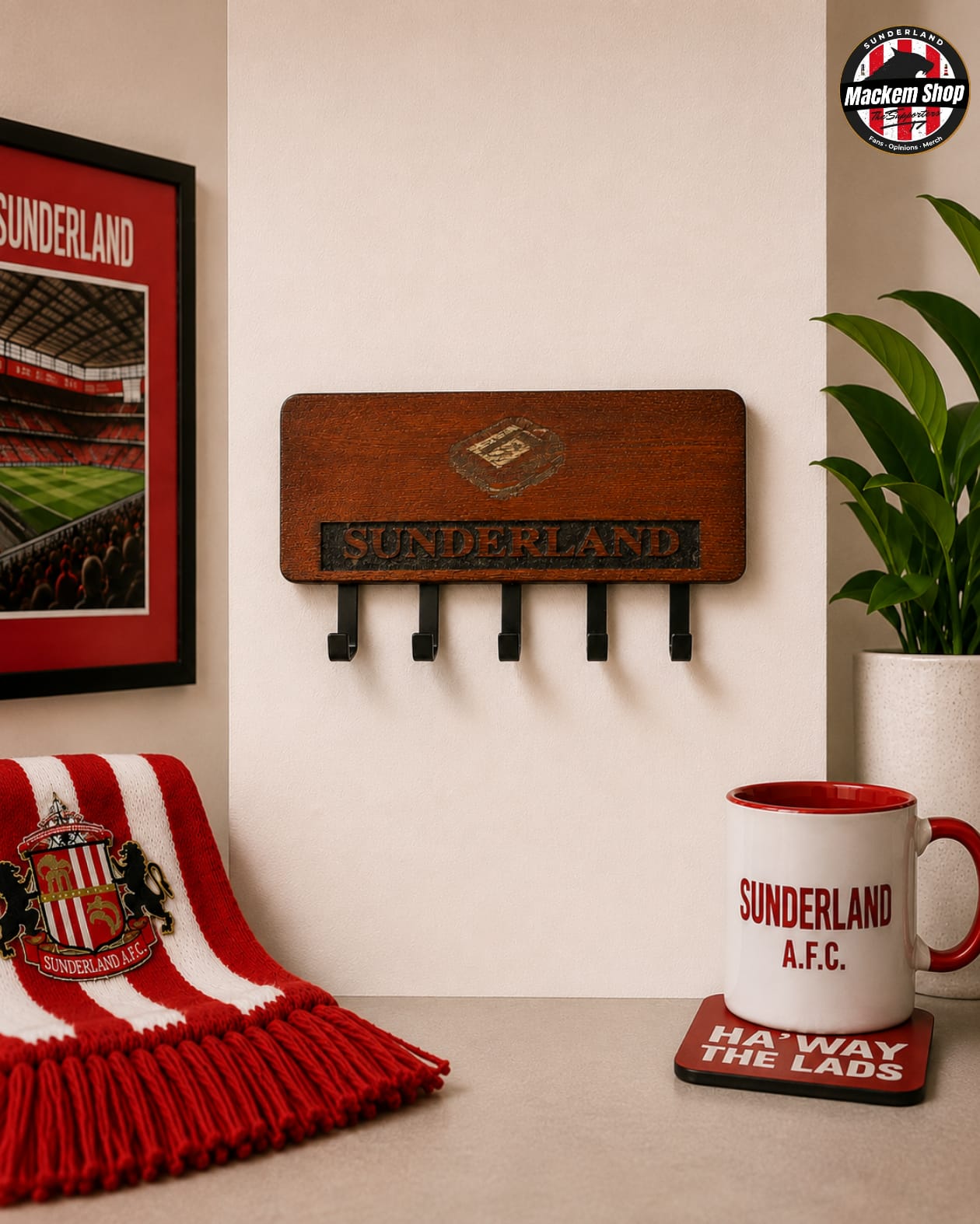 A wooden Sunderland AFC wall-mounted key holder with five hooks, shown in a styled room setting with a red and white striped scarf, a framed Sunderland poster, a plant, and a Sunderland mug on a coaster.