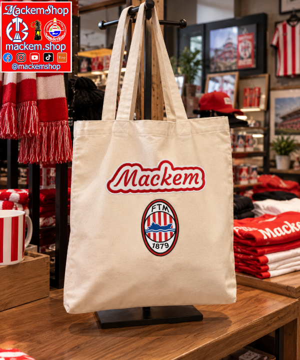 A cream canvas tote bag displayed on a stand inside a retail store. The bag features a red and white embroidered 'Mackem' logo and the FTM 1879 crest. A MackemShop logo is visible on top right corner.