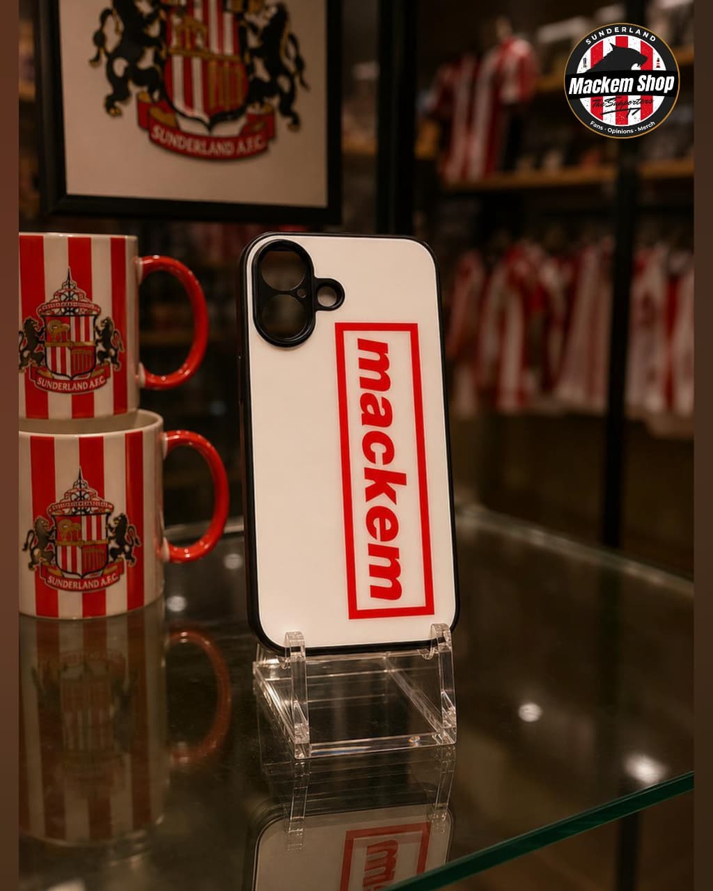 Phone case with 'mackem' branding and mugs in the background