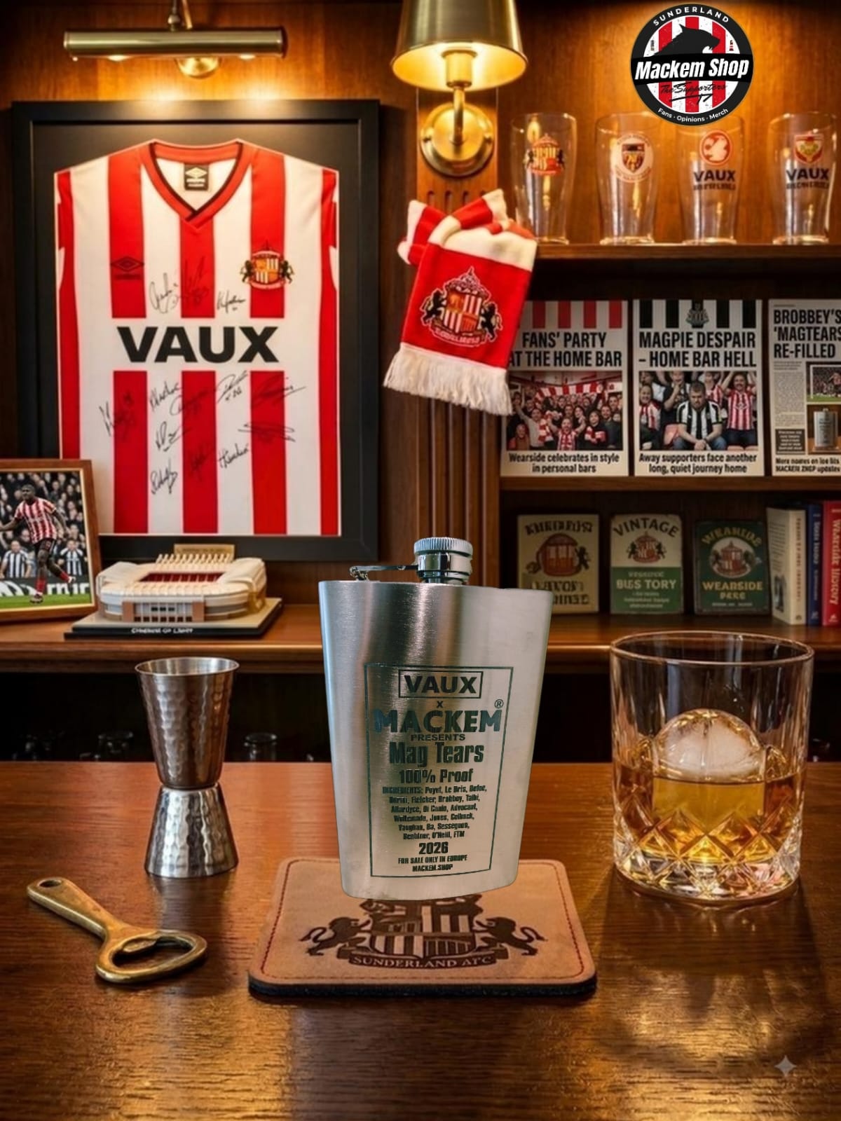 A silver metal flask with a Vaux Maccan label sits on a wooden bar counter, surrounded by a glass of amber liquor, a metal jigger, and a bottle opener. In the background, a framed red and white striped Vaux jersey hangs on a wooden wall with shelves of glasses and memorabilia.