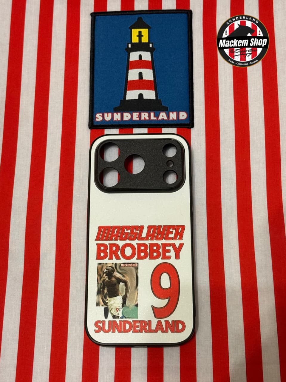 Phone case with lighthouse design and text on a red and white striped background