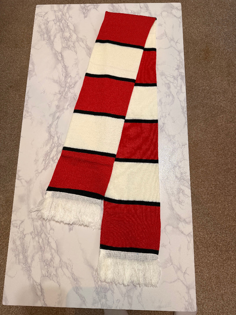 Red and white striped scarf with black accents on a marble surface