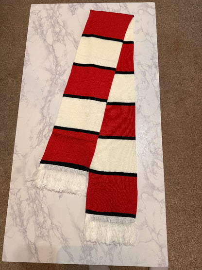 Red and white striped scarf with black accents on a marble surface