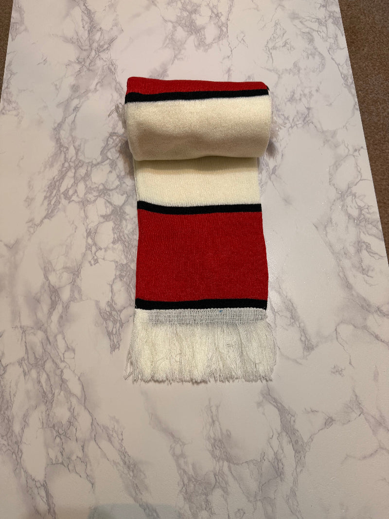 Red and white scarf with black stripes on a marble surface