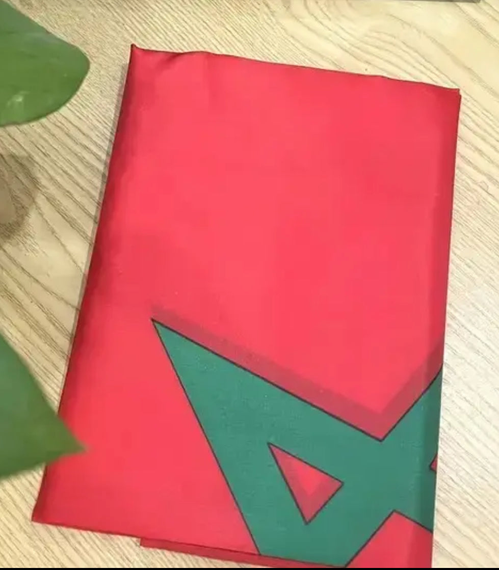 Red fabric with green geometric design on a wooden surface