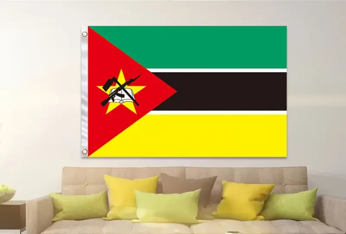 Flag of Mozambique hanging on a wall above a sofa with colorful cushions.