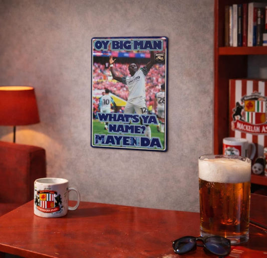 Room interior with a Metal sign by Mackem shop, mug, and beer glass on a table. 